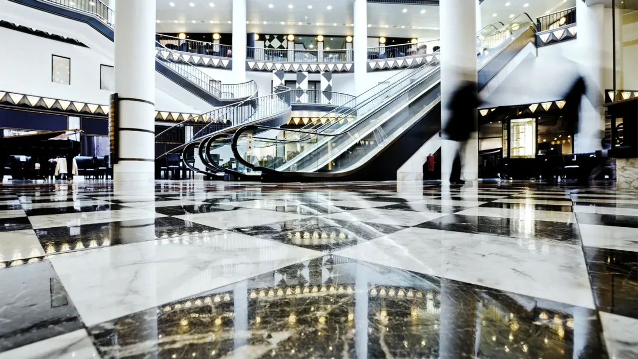 Rolltreppen und Ladenzeilen in einem hellen Einkaufszentrum