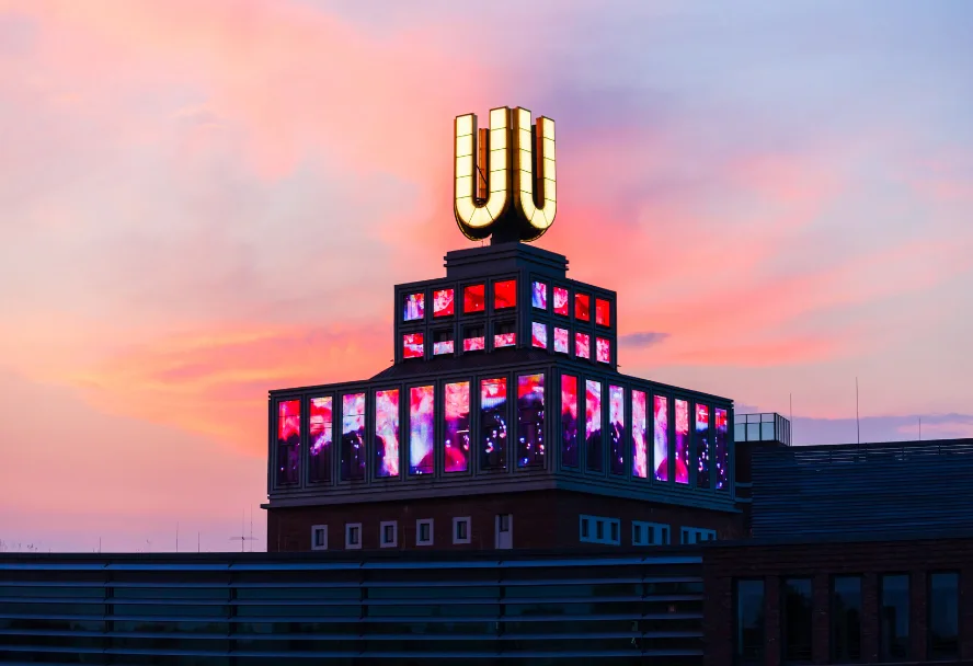 Das Dortmunder U im Abendrot, das gelbe Zeichen auf dem Turm leuchtet