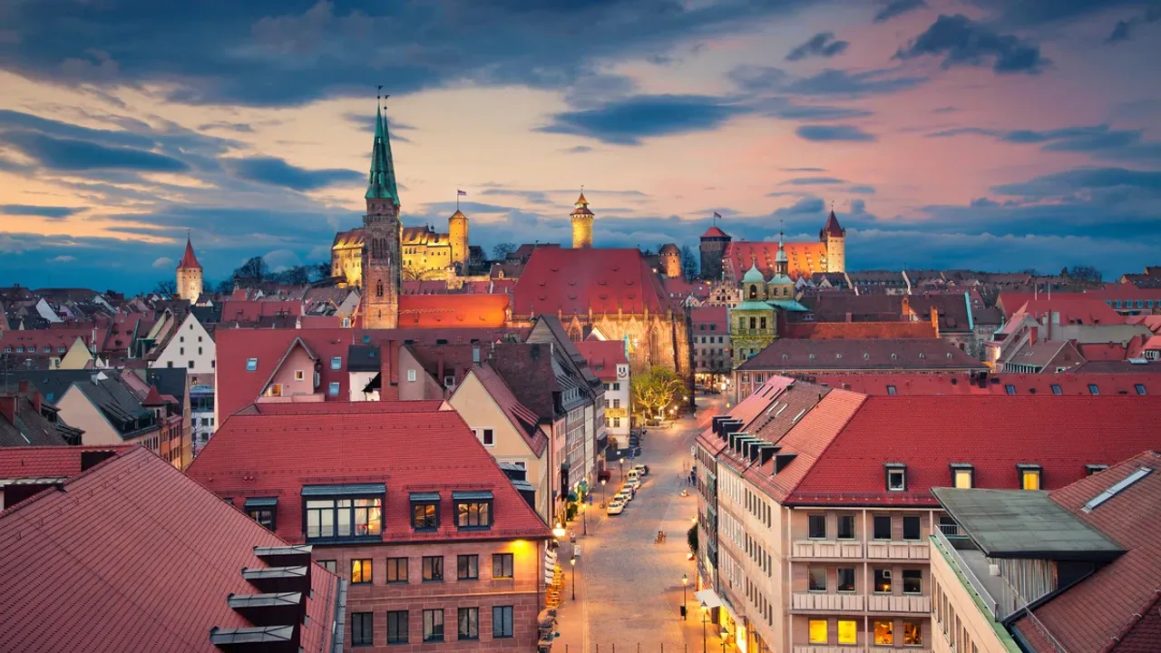 Die Dächer der Nürnberger Altstadt im Abendrot, dahinter die Kaiserburg