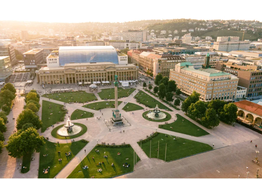 Der Stuttgarter Schlossplatz von oben im Abendlicht, mit Jubiläumssäule, Brunnen und Königsbau