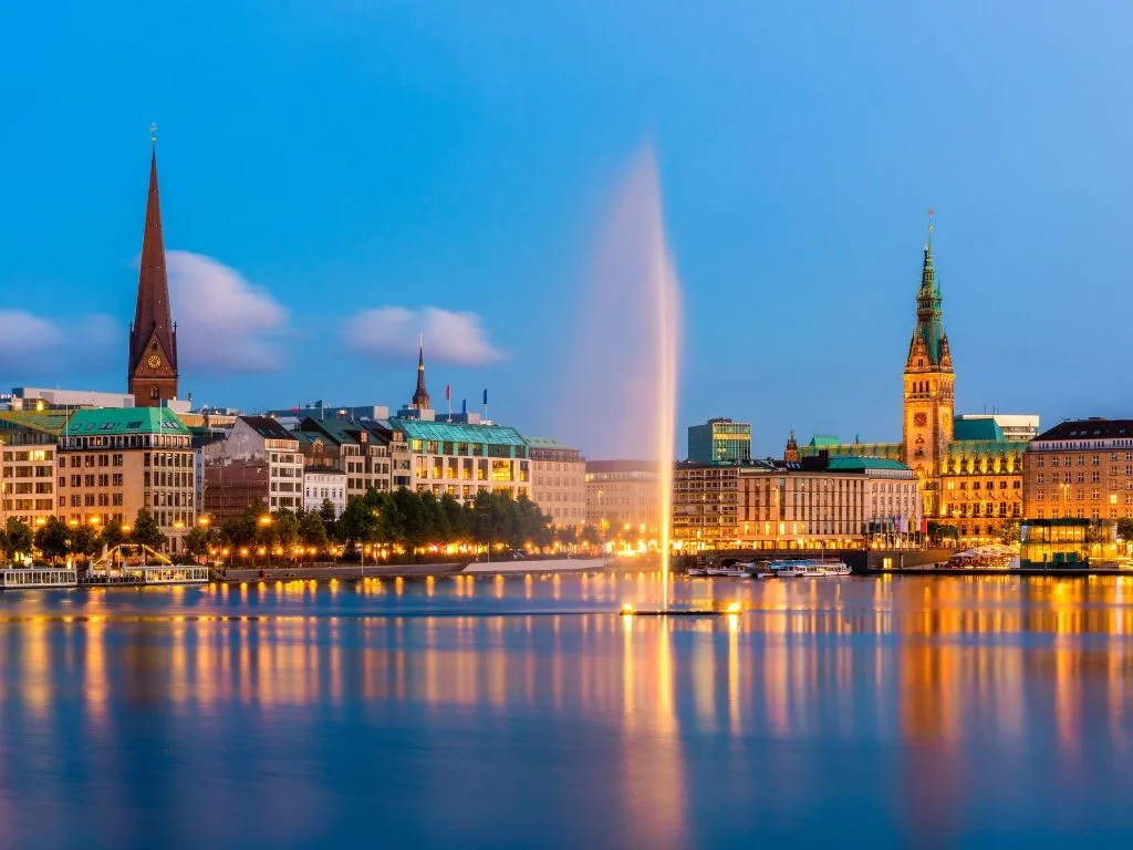 Die Binnenalster zur blauen Stunde, die Alsterfontäne in der Mitte, rechts der beleuchtete Rathausturm