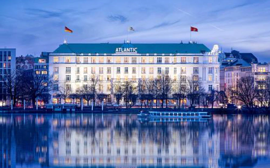 Das Hotel Atlantic an der Außenalster in St. Georg zur blauen Stunde, die Fassade im Wasser gespiegelt