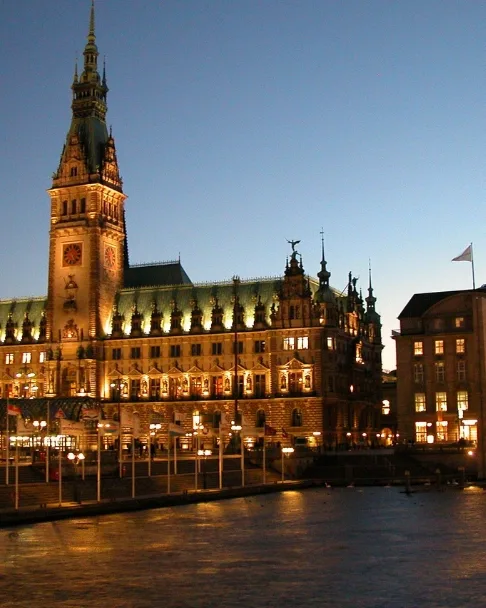 Das Hamburger Rathaus bei Nacht, gespiegelt in der Kleinen Alster